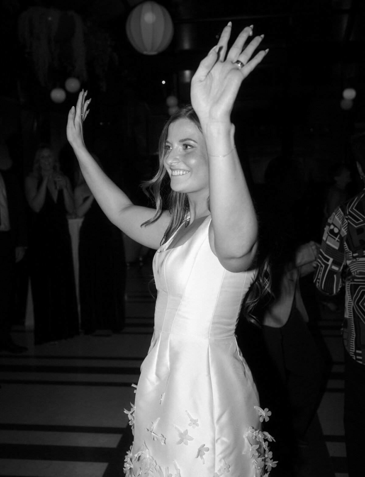 a bride dances in her short second look wedding reception dress at Shinola Hotel