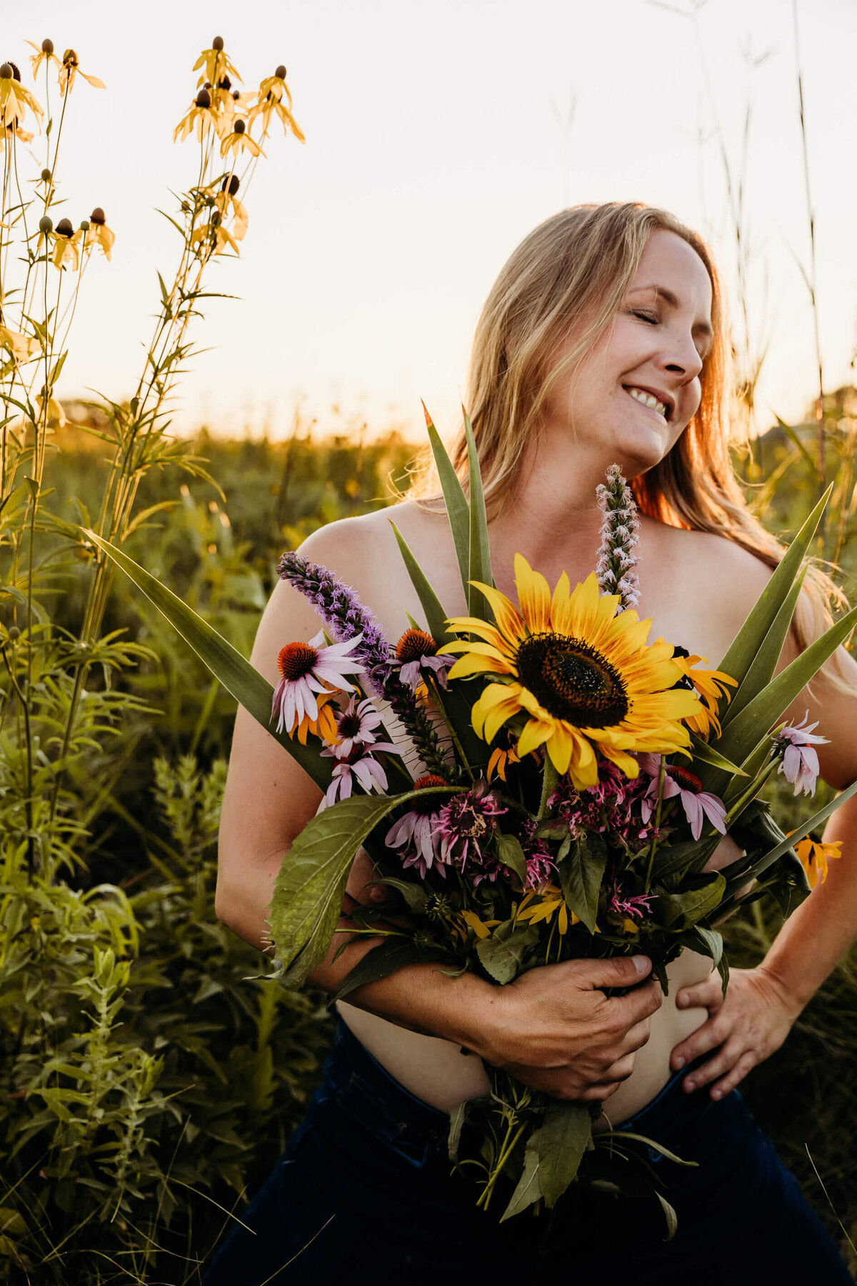 woman smiling while holding a bouquet of flowers over her chest by Ashley Kalbus