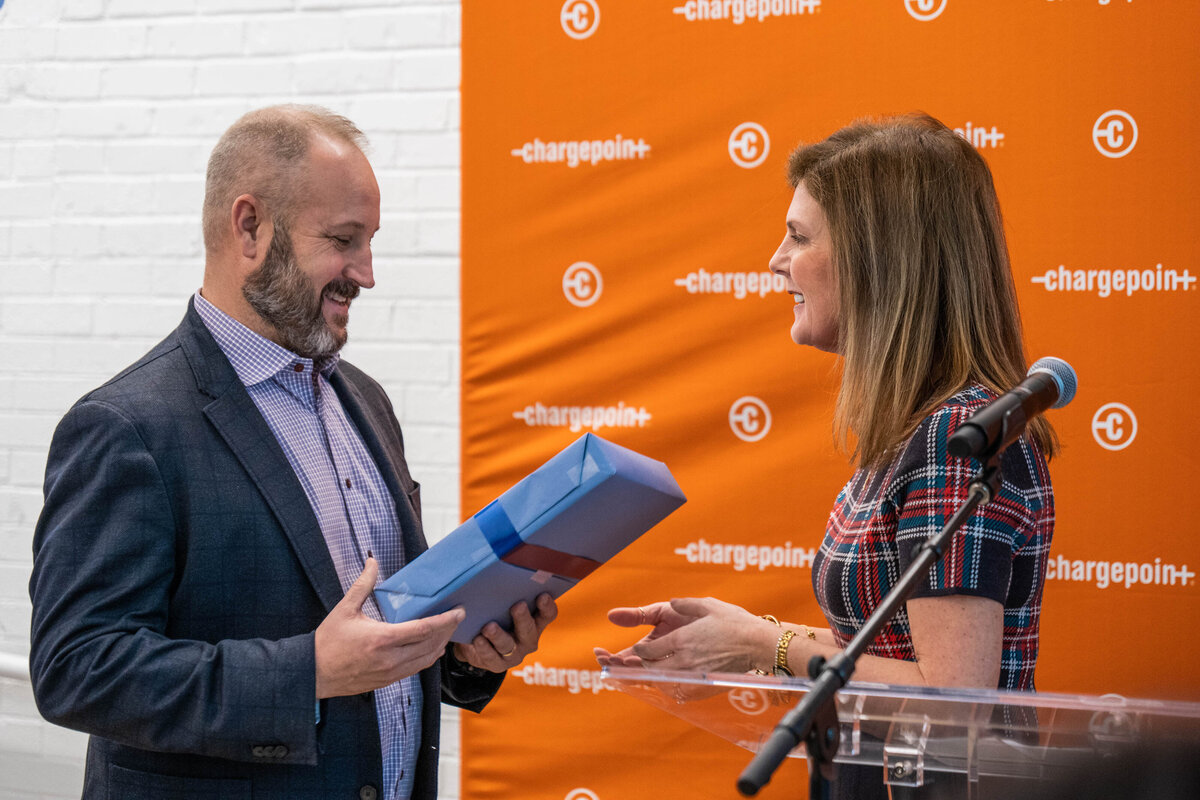 a person smiling and handing someone else a present 