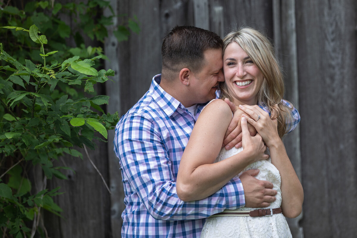 engaged couple hugging by barn new jersey
