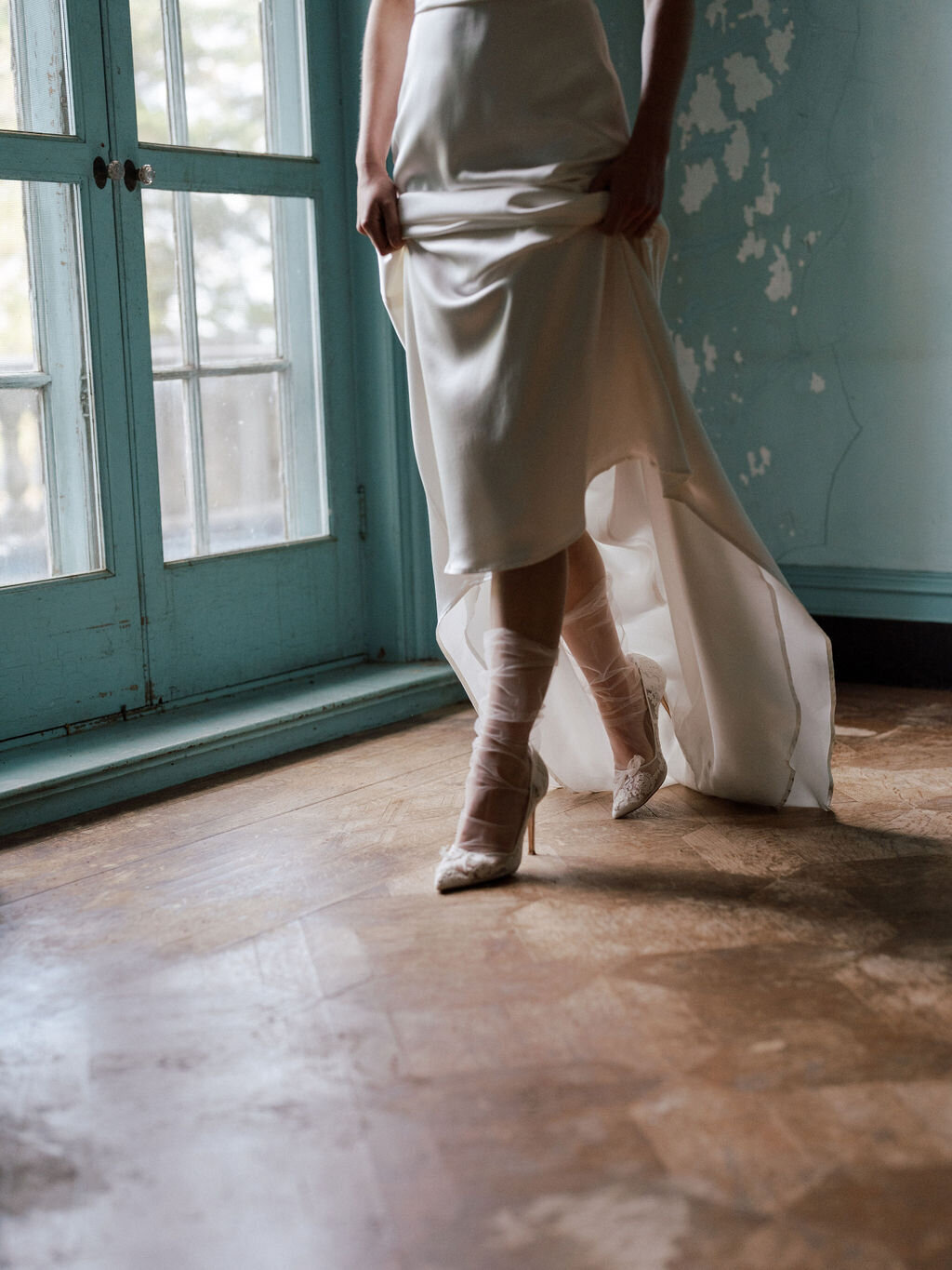 bride lifting wedding dress to show wedding shoes and socks