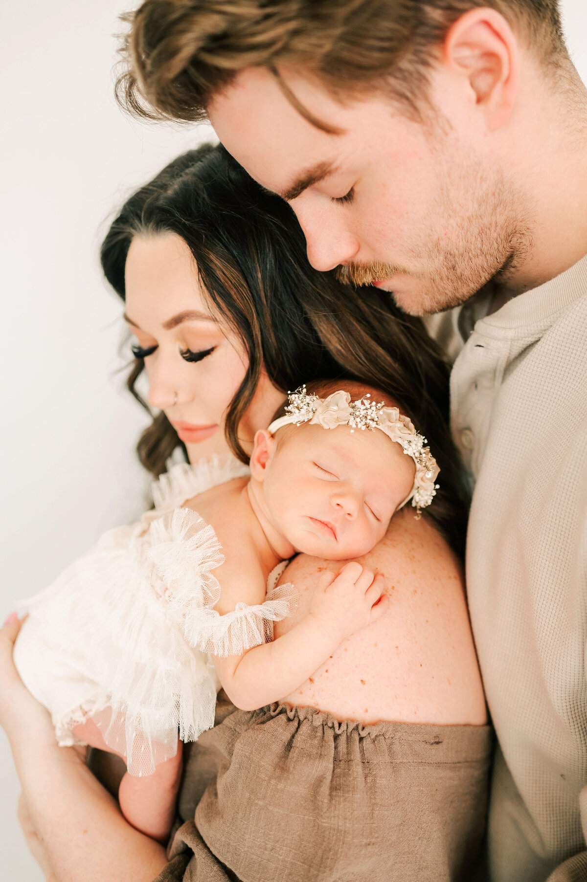 Springfield MO newborn photography of parents holding sleeping baby girl with eyes closed