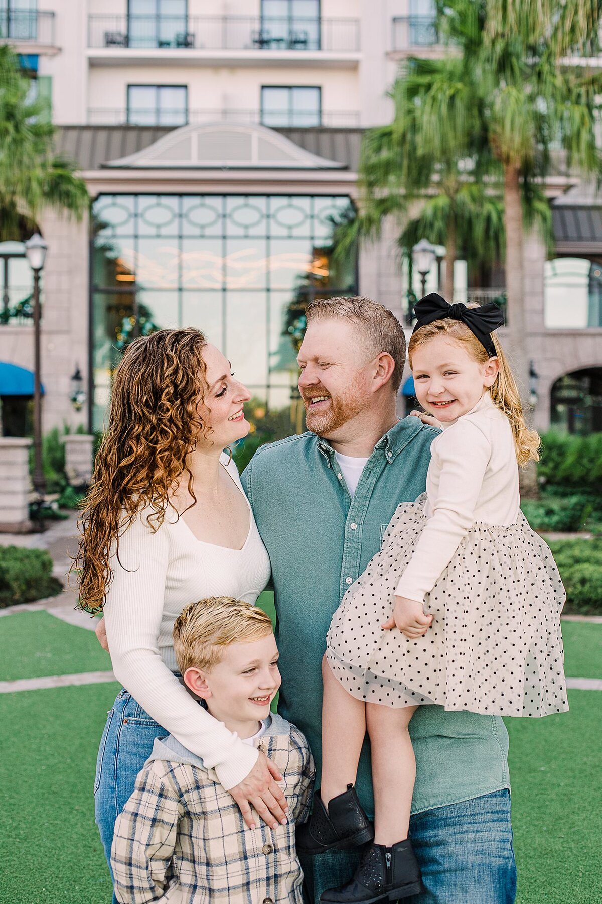 Family looking at each other and smiling for their Christmas photo at Disney's Riviera Resort