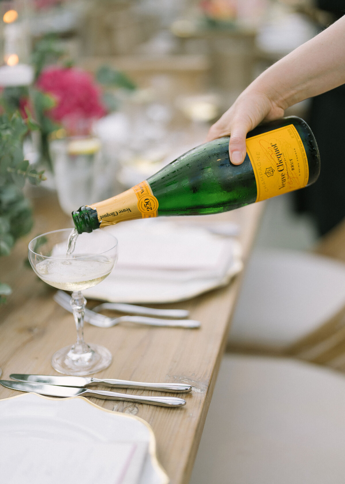 A waiter pouring champagne at a finely set wedding table at Saddle Country Club.