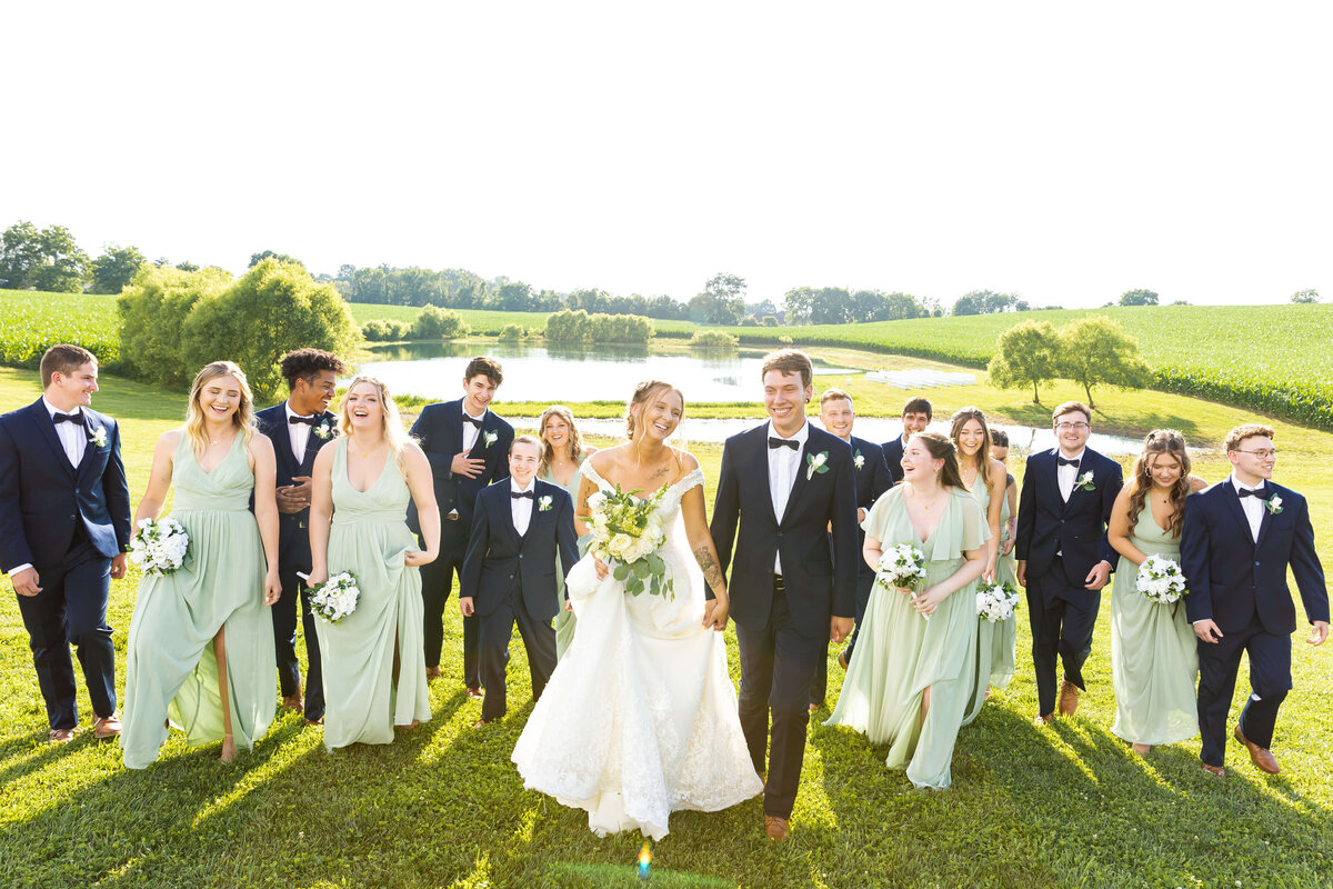 Wedding party portraits with bridesmaids in pale green dresses and groomsmen in black suits at The Ruby Cora wedding venue in Clarksville, TN