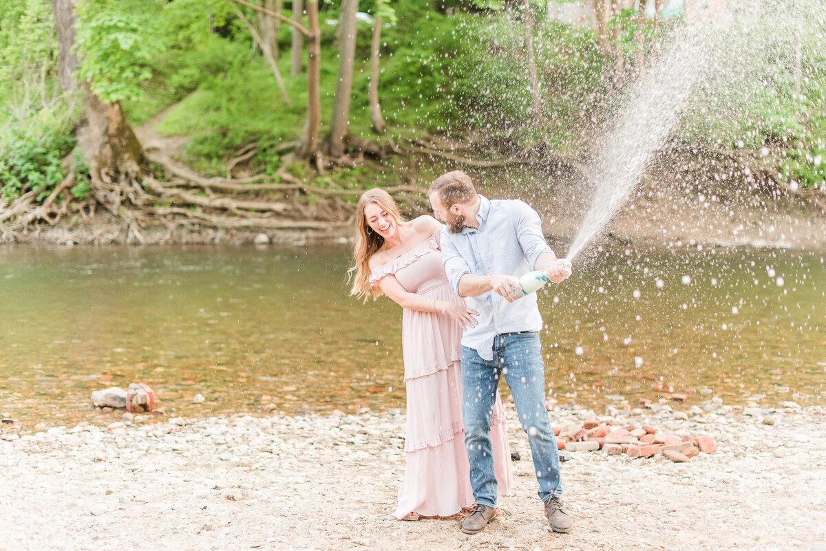 couple popping champagne by patapsco river