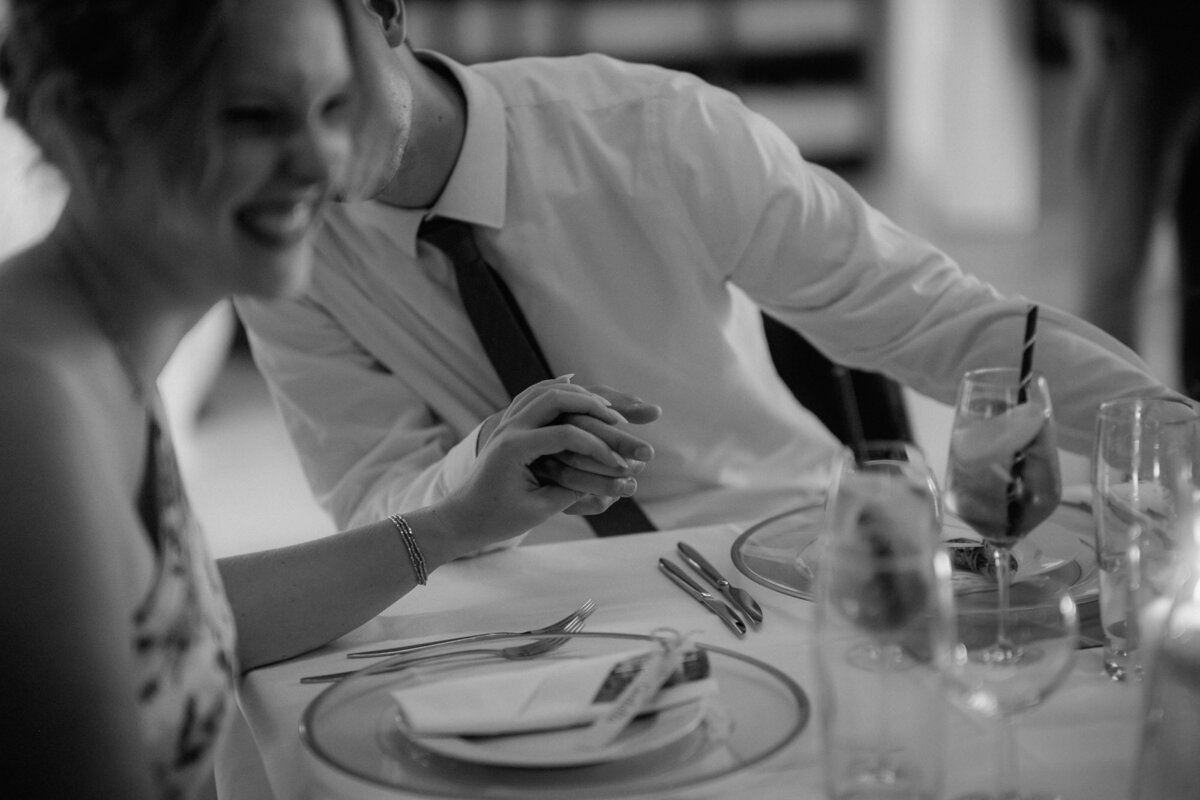 Bride and groom have a fun conversation during dinner.