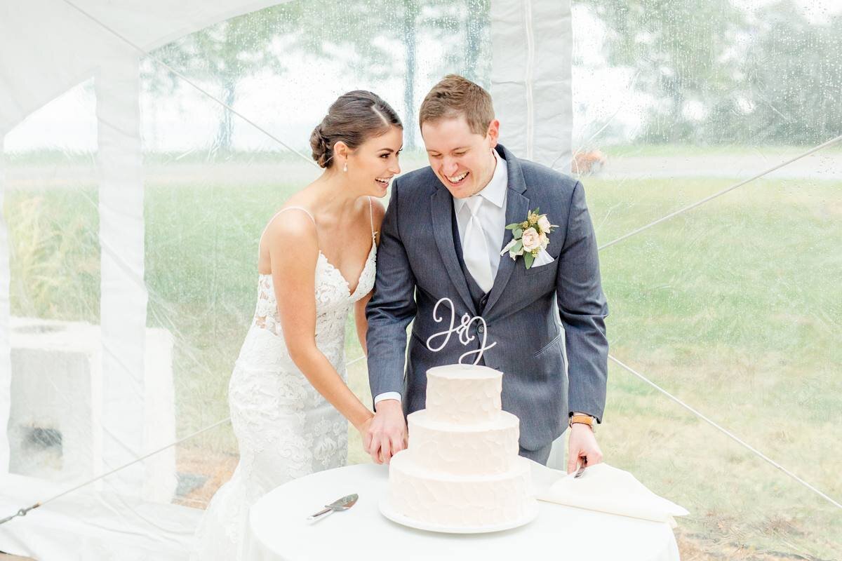 bride and groom cutting all white modern cake