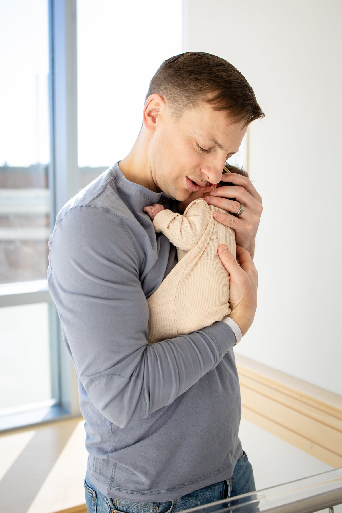 New dad shushing baby while holding it close