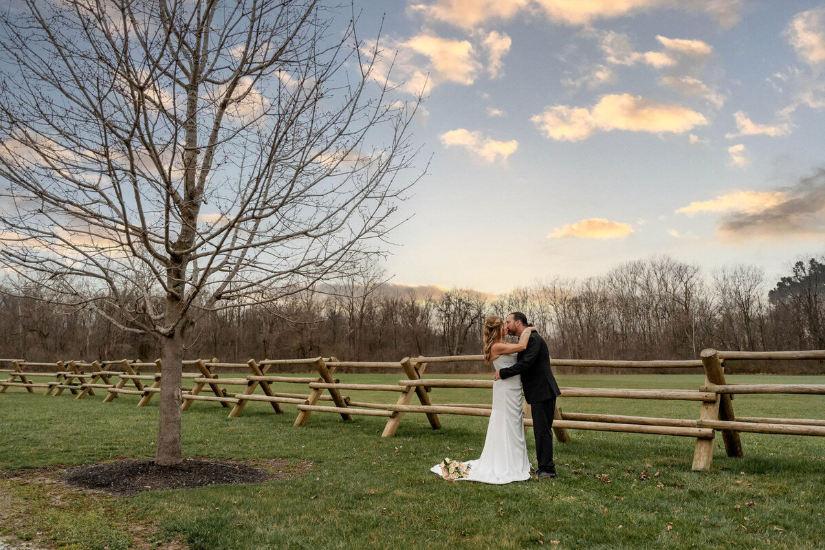 Bride and grooms kiss at open space venue
