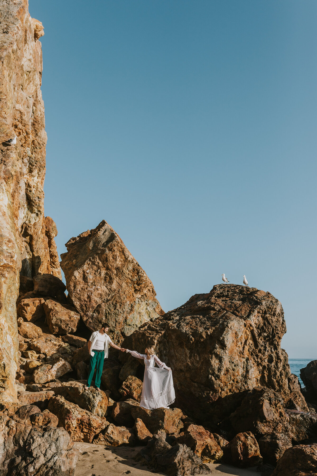 Couple standing by rock formations, adventure elopement in Indiana.