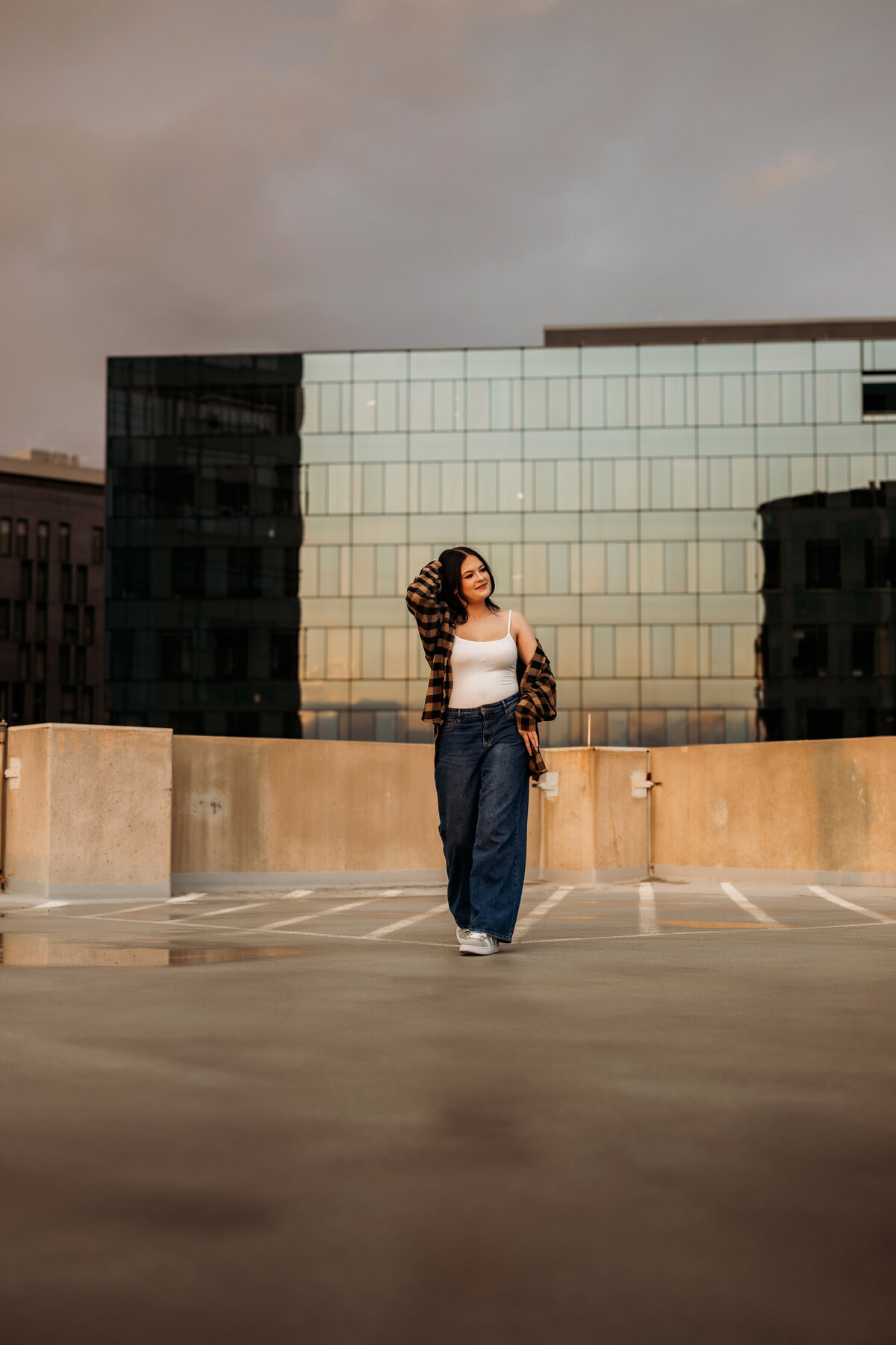 high school senior girl walks on a rooftop in downtown Denver for her urban senior portrait session