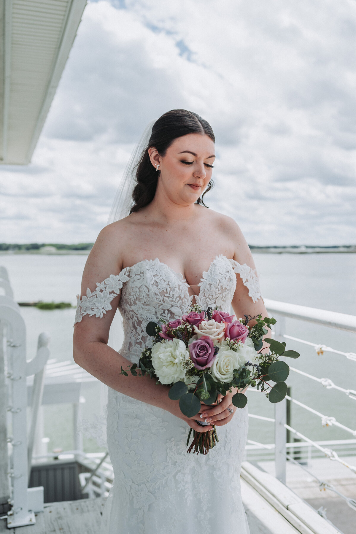 Bride gazes at her wedding gown in soft natural light while getting ready at Lesner Inn.