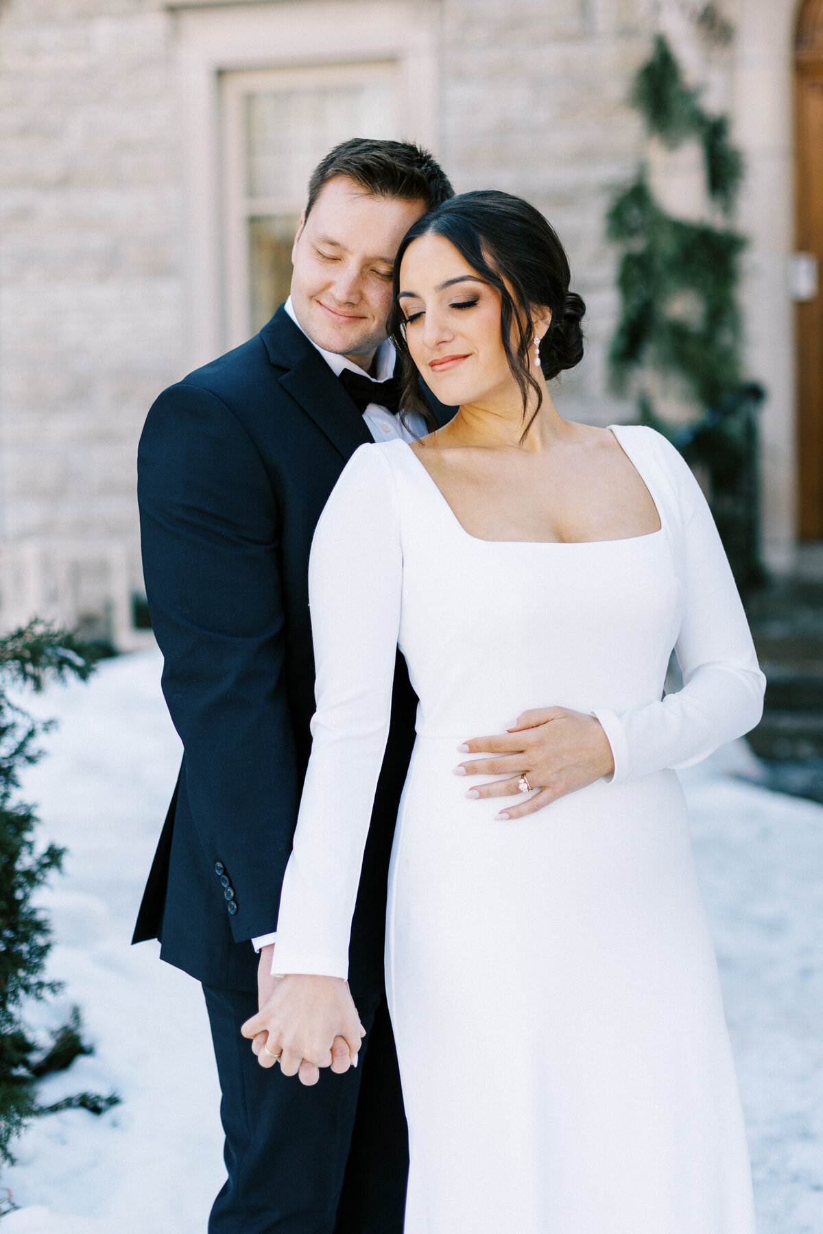 Bride and groom leaning with their heads and eyes closed at St. Paul College Club