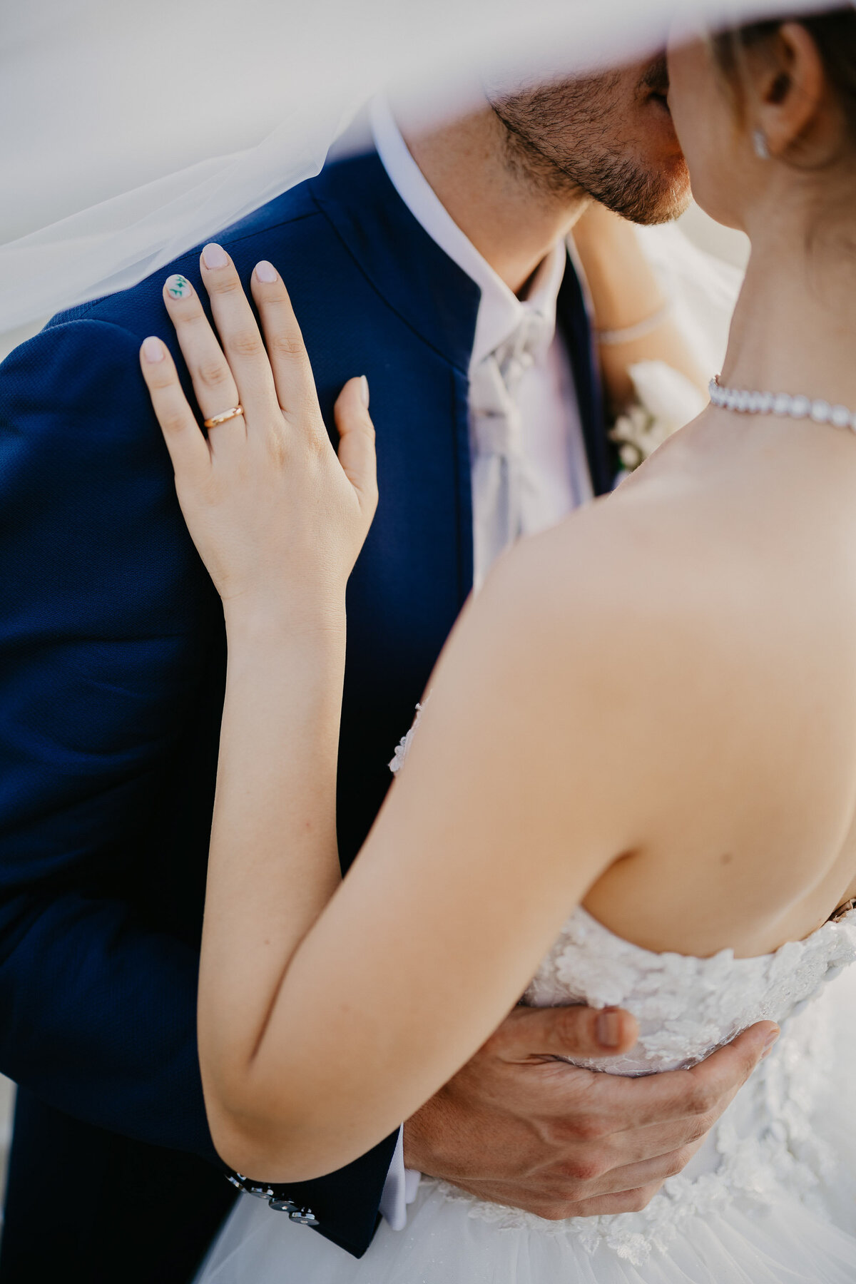 Romantic close-up of bride and groom kissing under the veil, wedding photographer Tuscany.