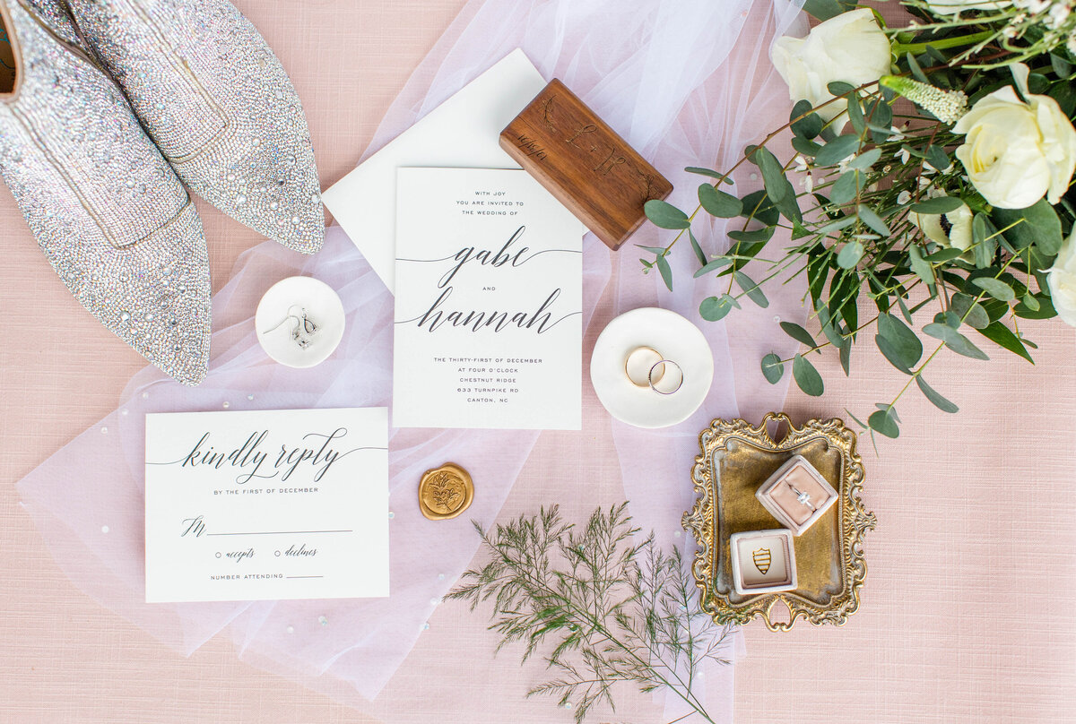 flat lay with invitation suite and pink and silver tones