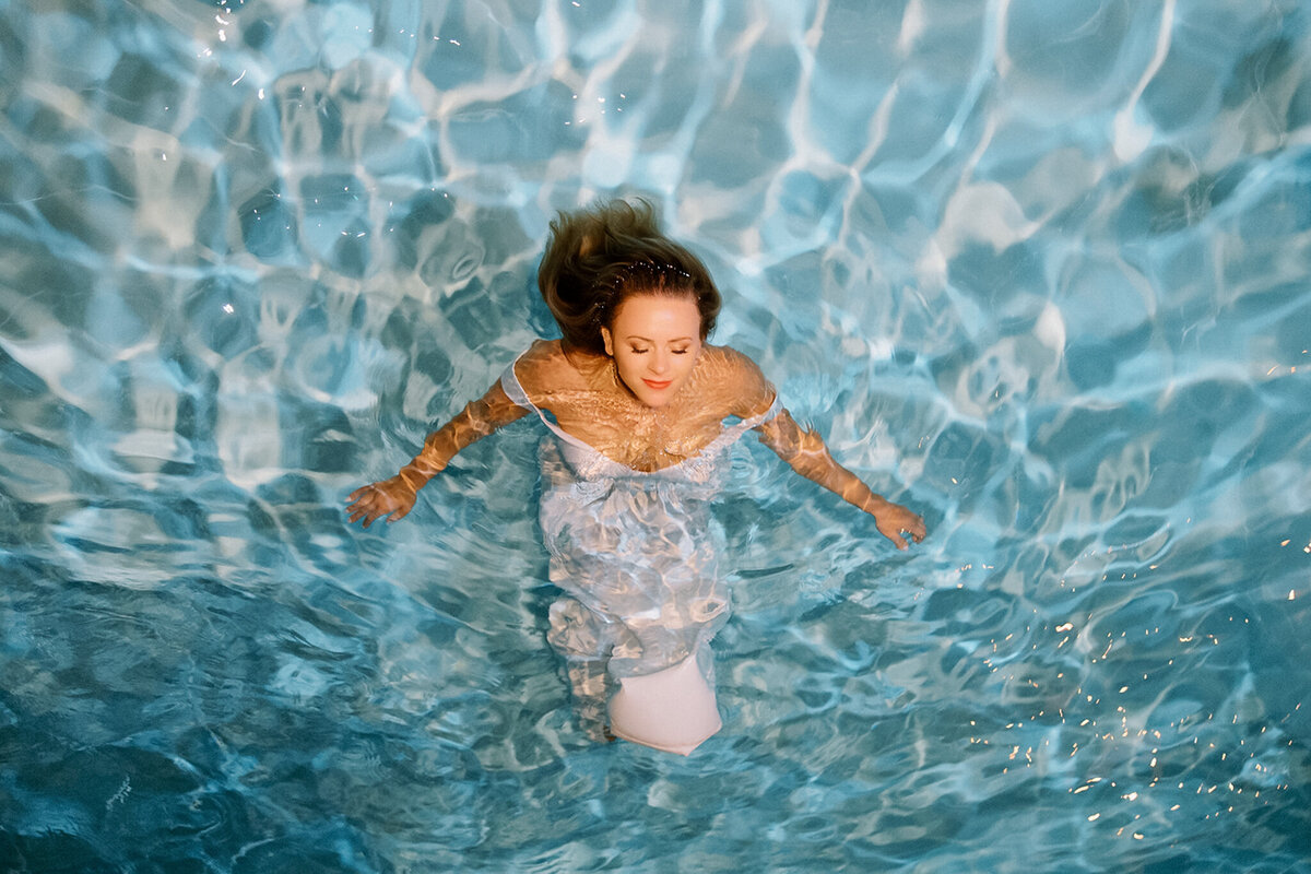 Bride Floating in a Pool in her wedding dress
