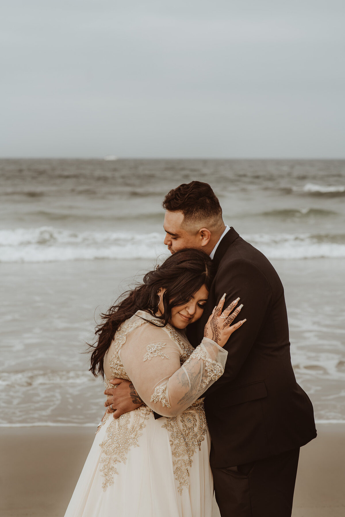 a newlywed couple hugging each other bride laying her head on the groom's shoulder