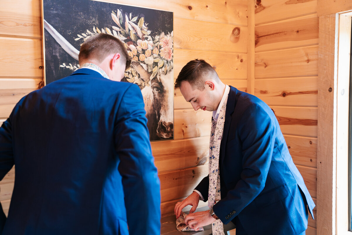 Candid moment of the groom adjusting his tie before the ceremony