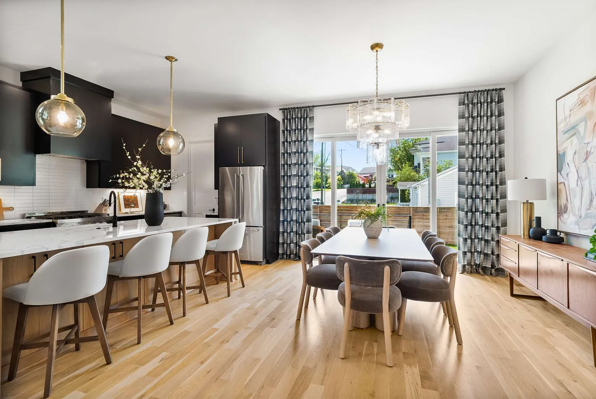 Modern Open Concept Kitchen and Dining Room with Black Cabinets and Brass Accents