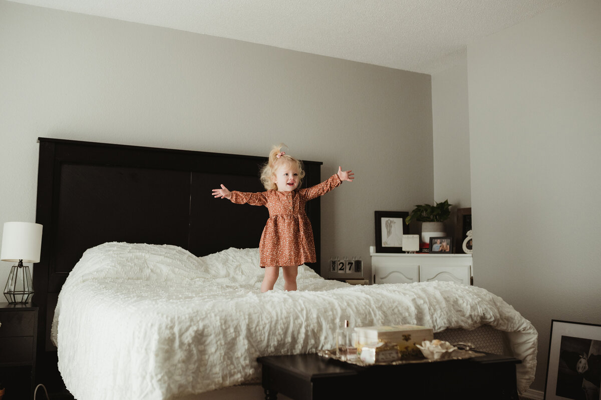 little girl playing on bed