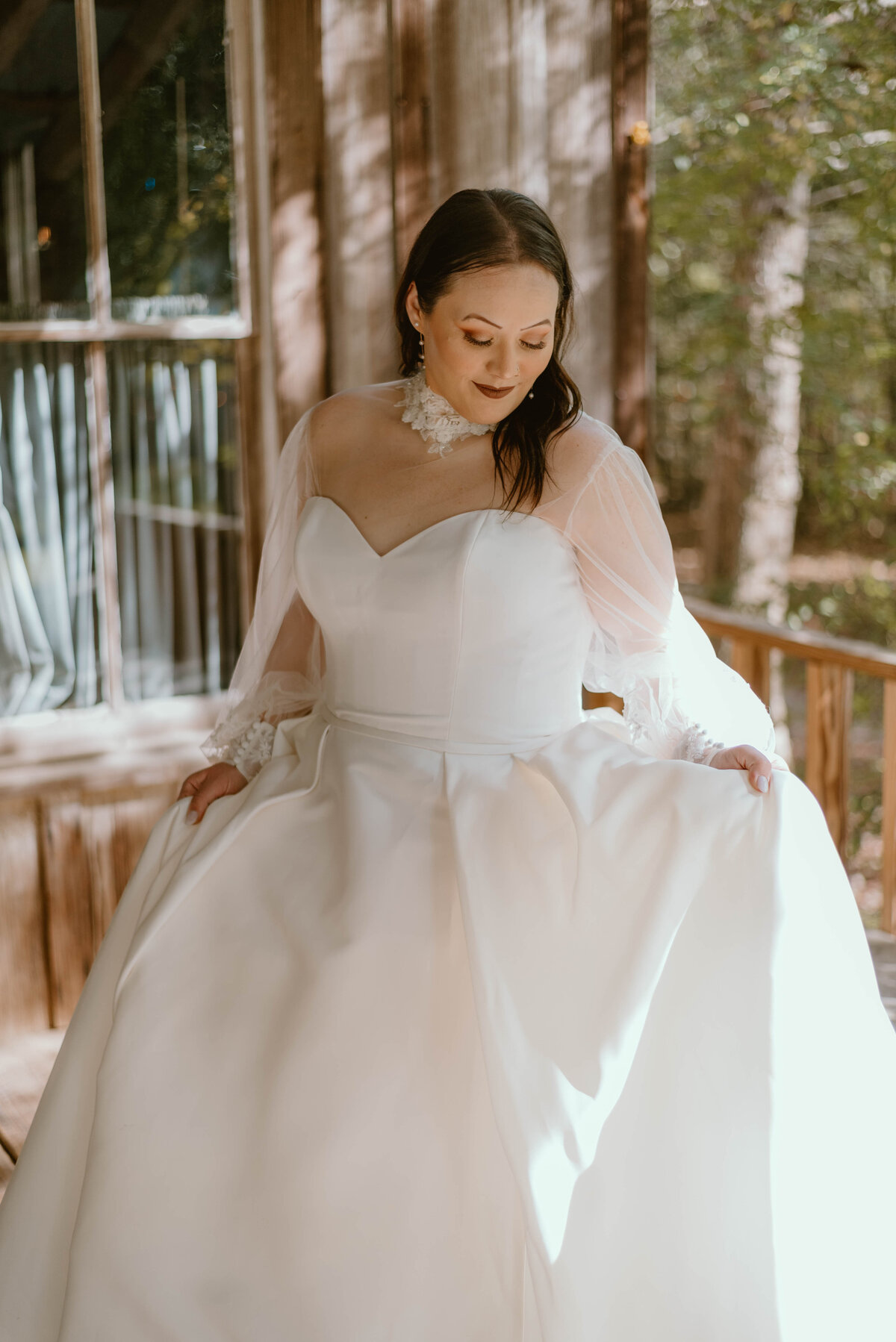 a bride in her wedding dress on a wooden porch.