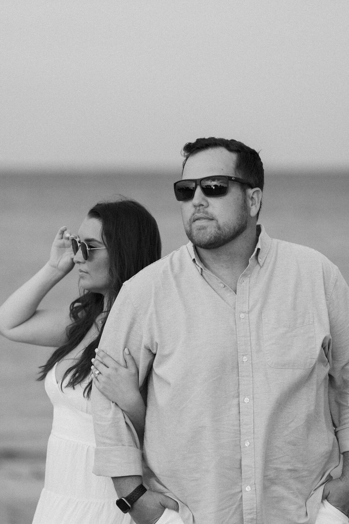 Couple on a beach wearing sunglasses, captured by Miami wedding photographer Claudia Amalia, highlighting her lifestyle photography.