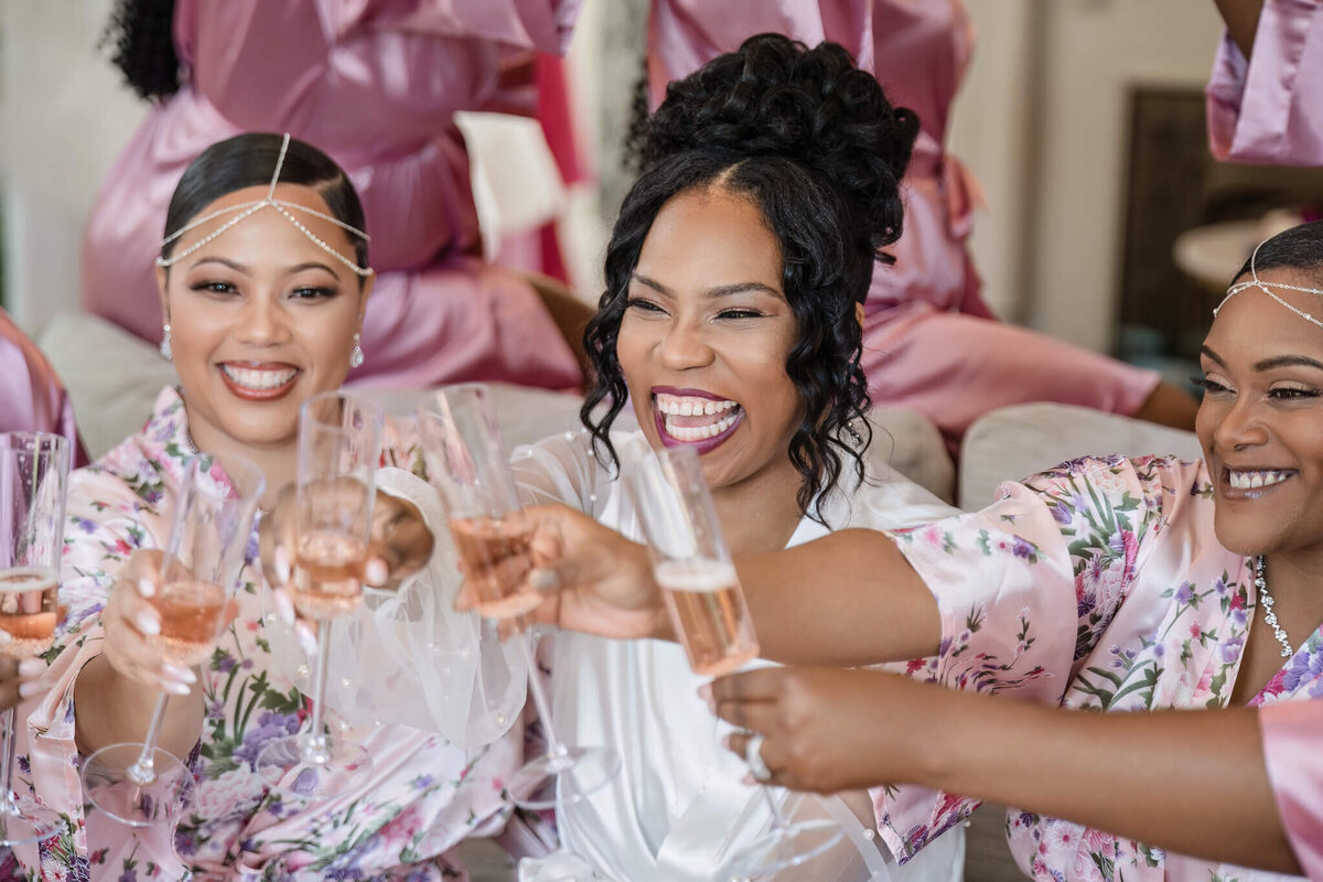 Bridesmaids raising glasses in celebration at a stylish wedding reception.