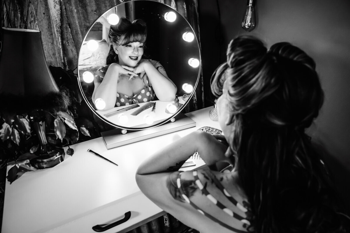 Woman in polika dots looking in a retro mirror  with pinup hair in  Minnesota