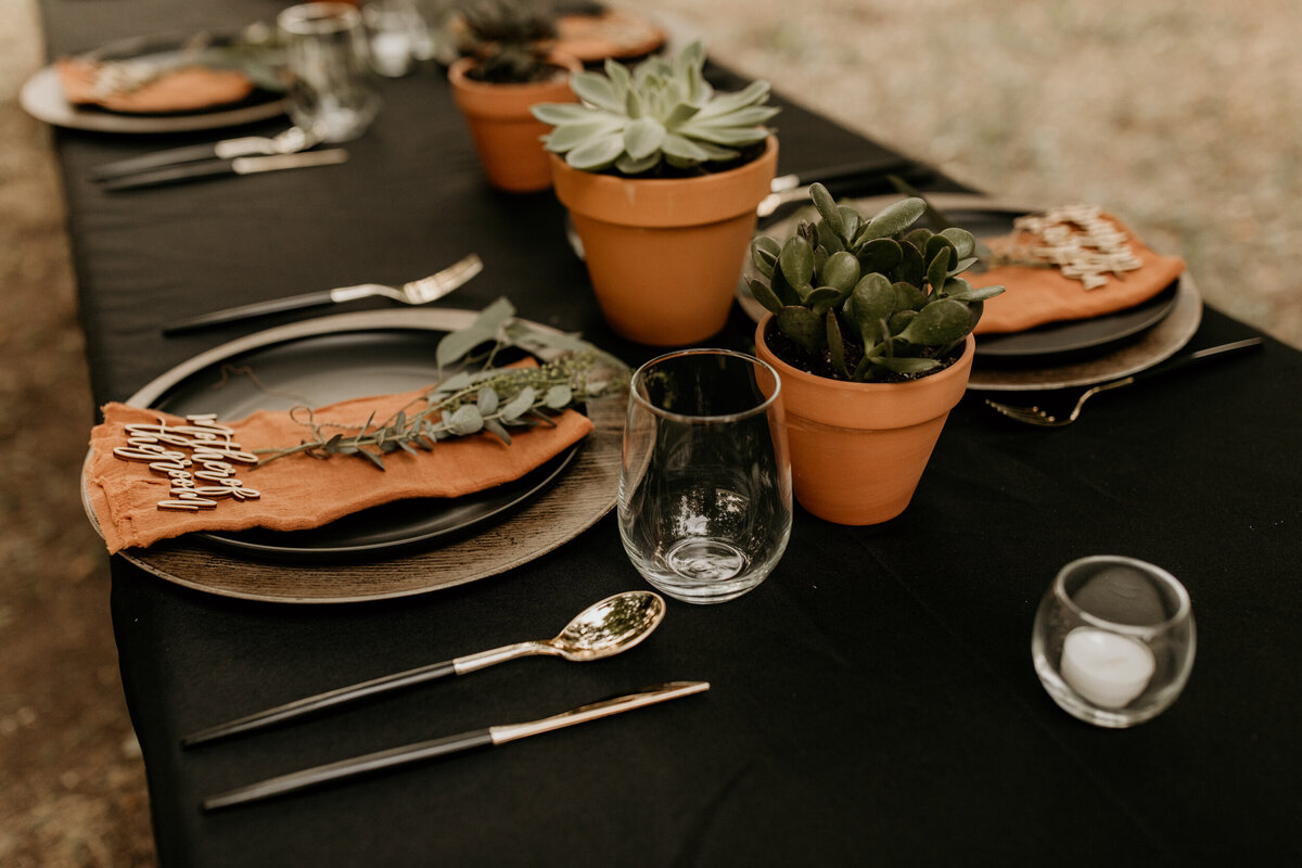 black and rust orange themed place settings for an intimate wedding in New Mexico