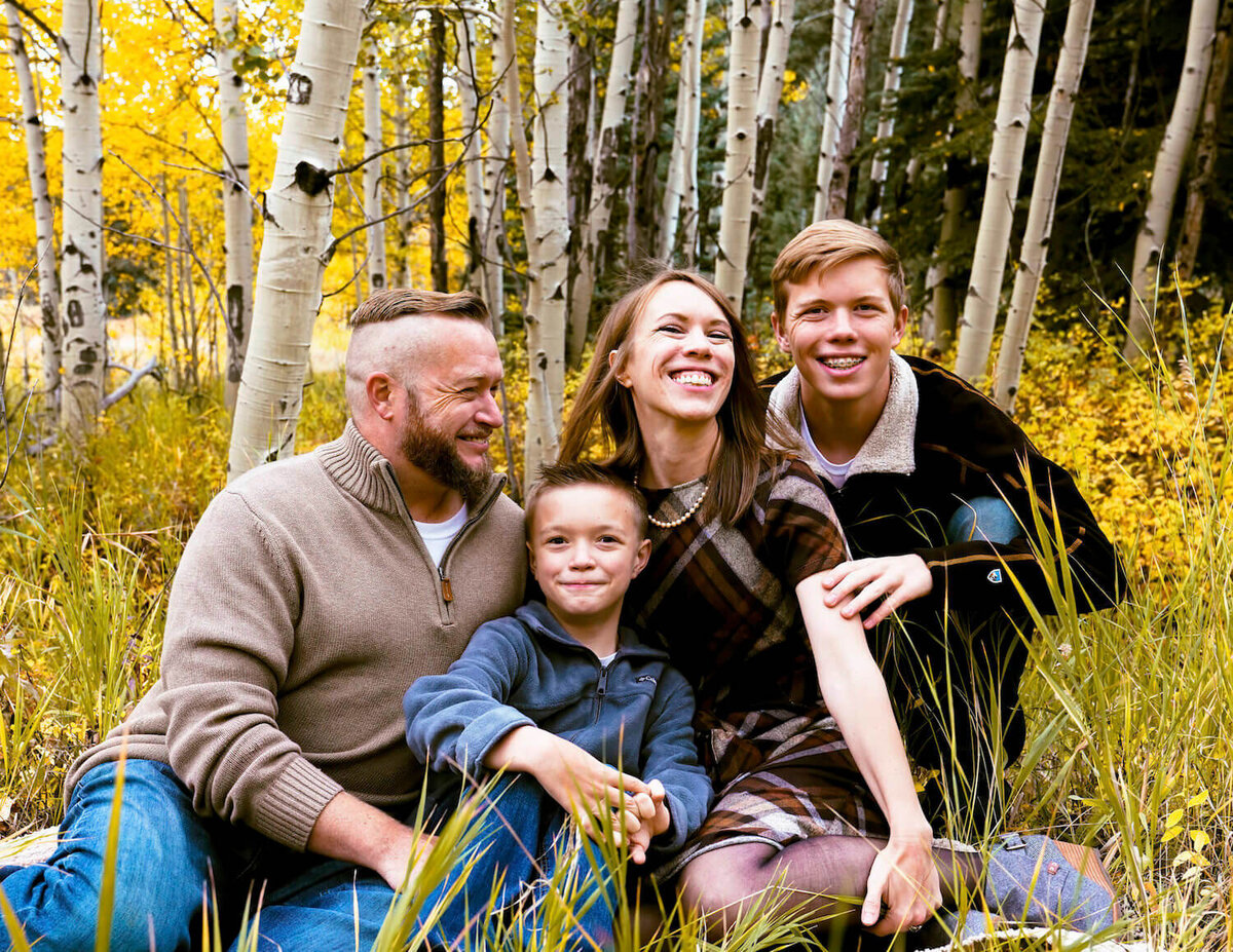 denver co family photographer - family sitting in field smiling