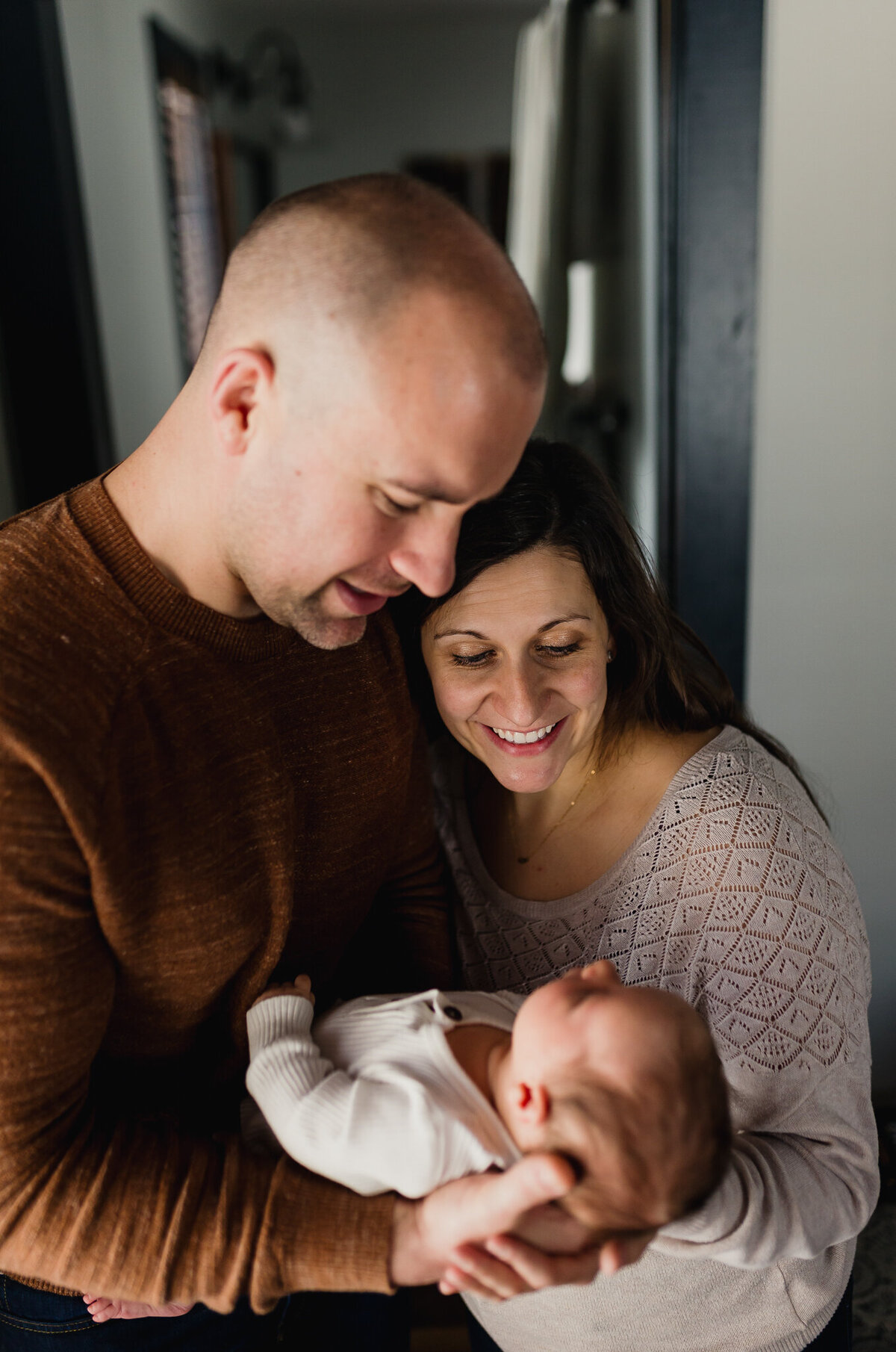 Infant photography of a mom and dad holding baby