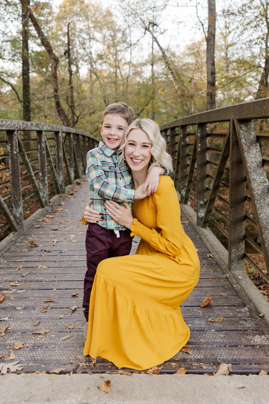 Mom and son hug on bridge in Flowery Branch
