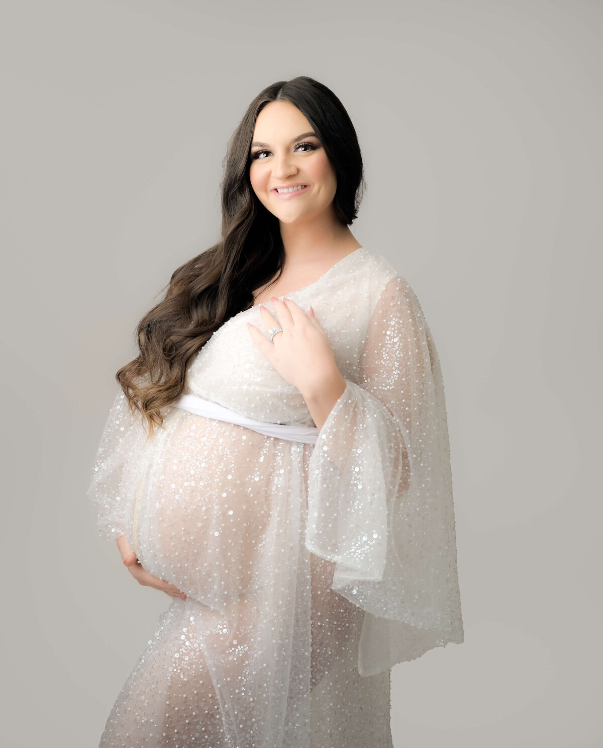 Cropped photo of pregnant woman  in white sequin robe for her maternity session in Bremerton.  Image by E. Benecki Photography