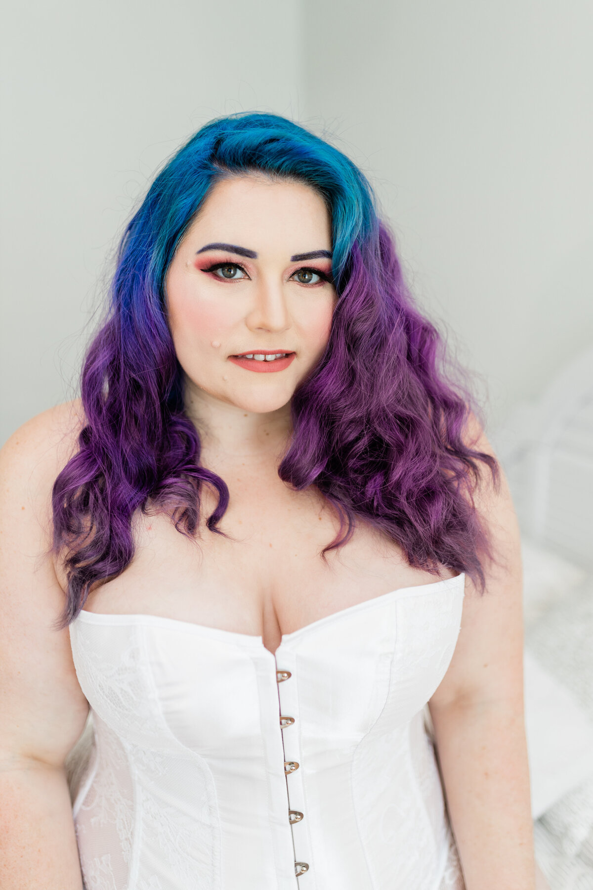 A woman in boudoir with purple hair