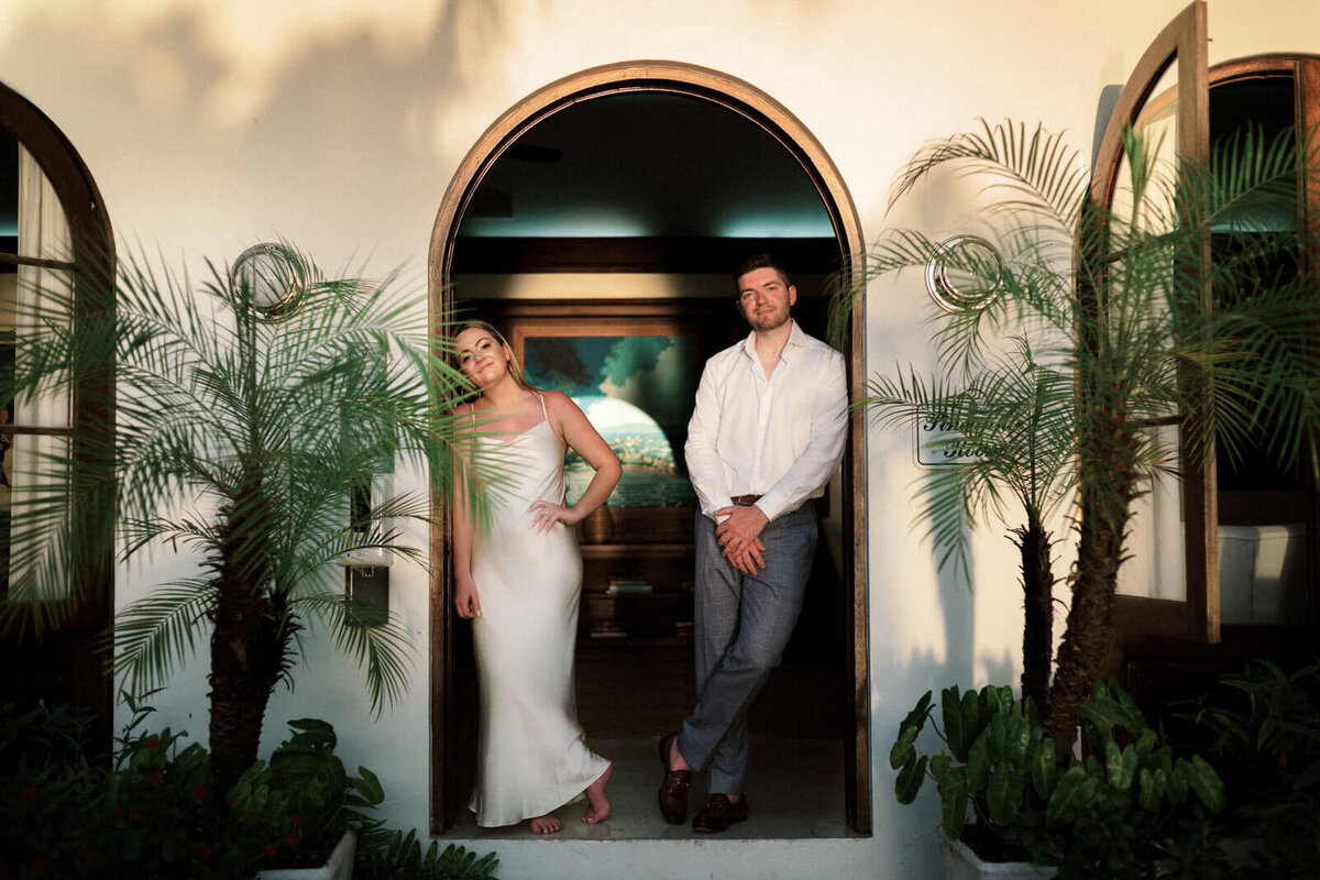 The engaged couple is standing at the door of a villa at Round Hill Hotel & Villas, Jamaica.