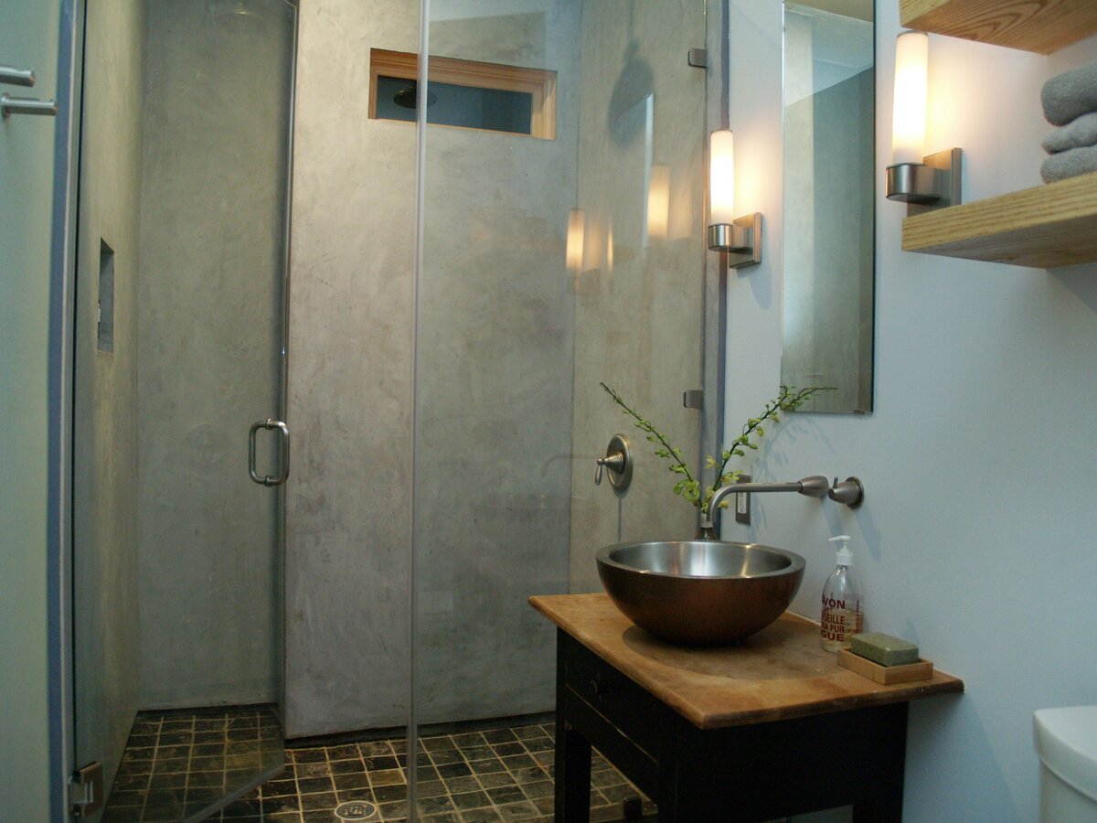 walk-in glass shower with stainless steel sink for bathroom. concrete bathroom walls.