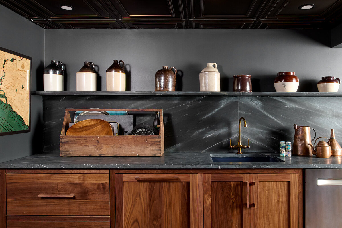 wooden kitchen cabinet with dark gray counter top and open shelf 