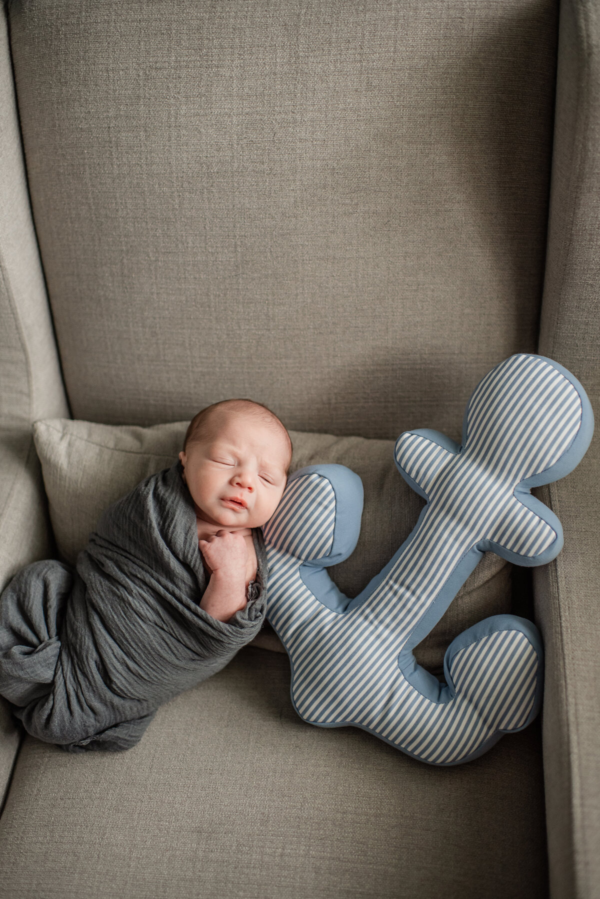 sleepy baby boy snuggles with anchor nursery pillow - maryland newborn photographer