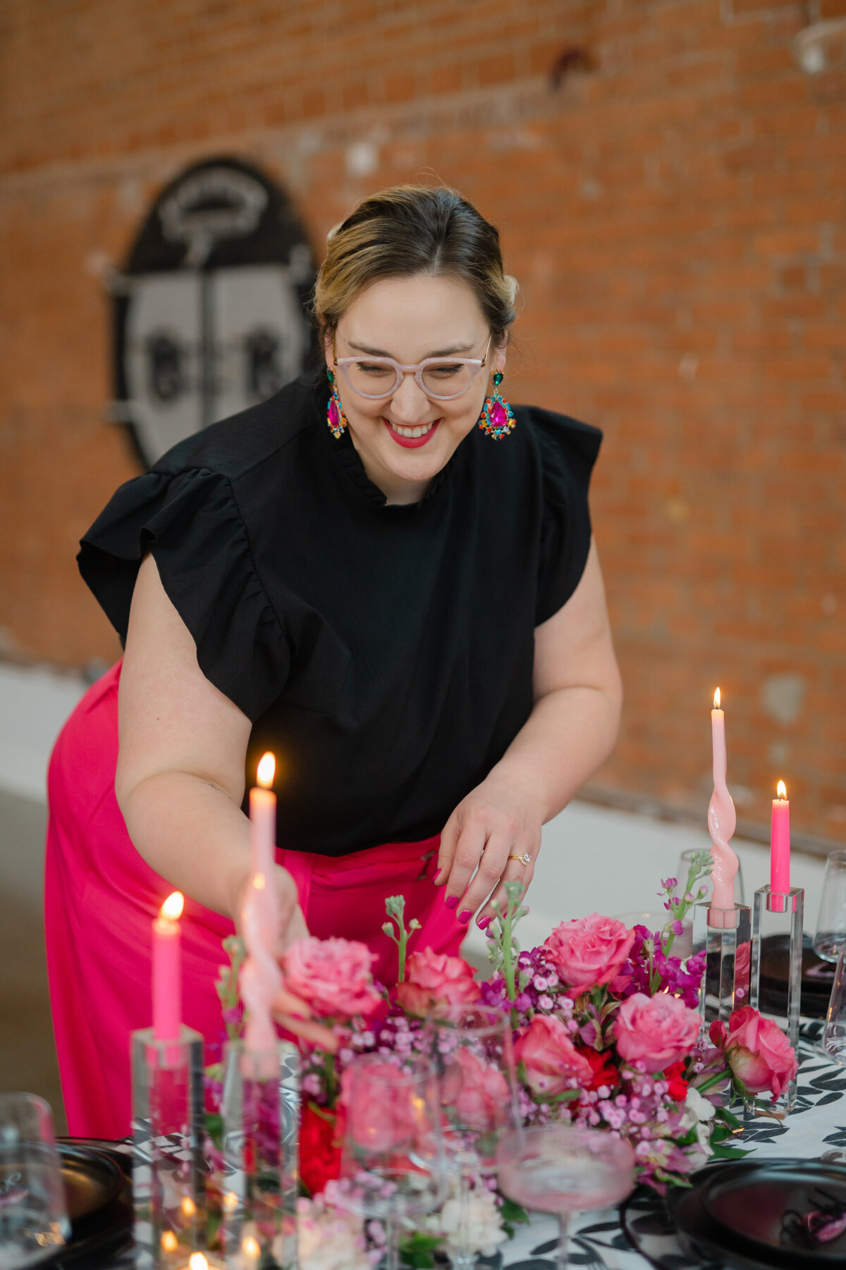 Rachel smiling while designing a black and pink tablescape