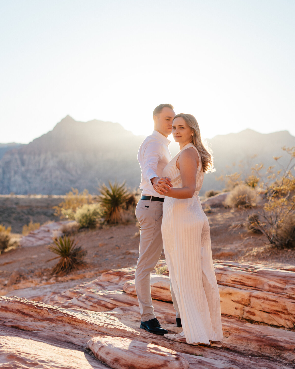 couple staring off into the distance at sunset in the desert