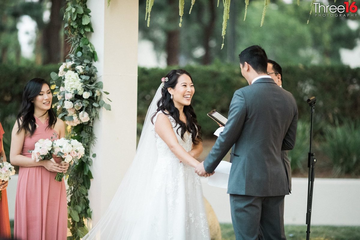 Bride laughs as the Groom shares his vows