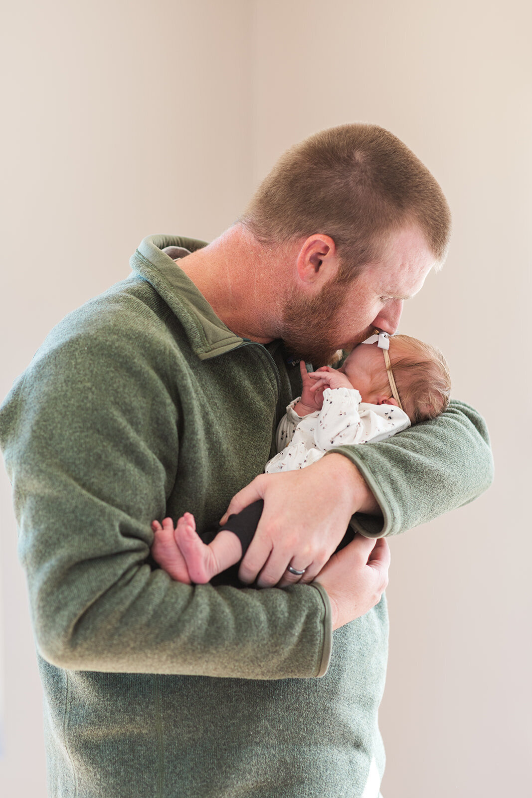 Father holding newborn during lifestyle portrait session