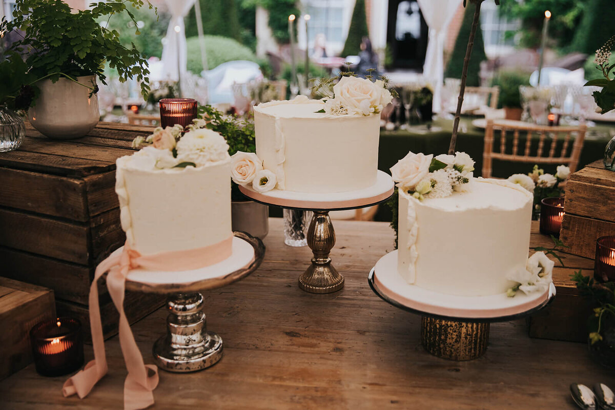 3 cakes on individual cake sands in a rustic setting