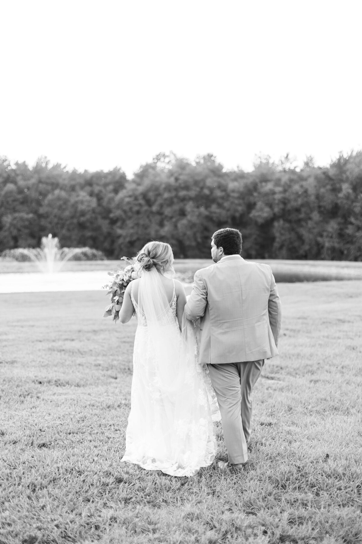 Bride and groom walking through the grounds at  The Barn at White Oaks, Murray, Kentucky