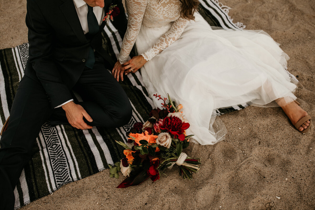 bride and groom legs sitting on a blanket