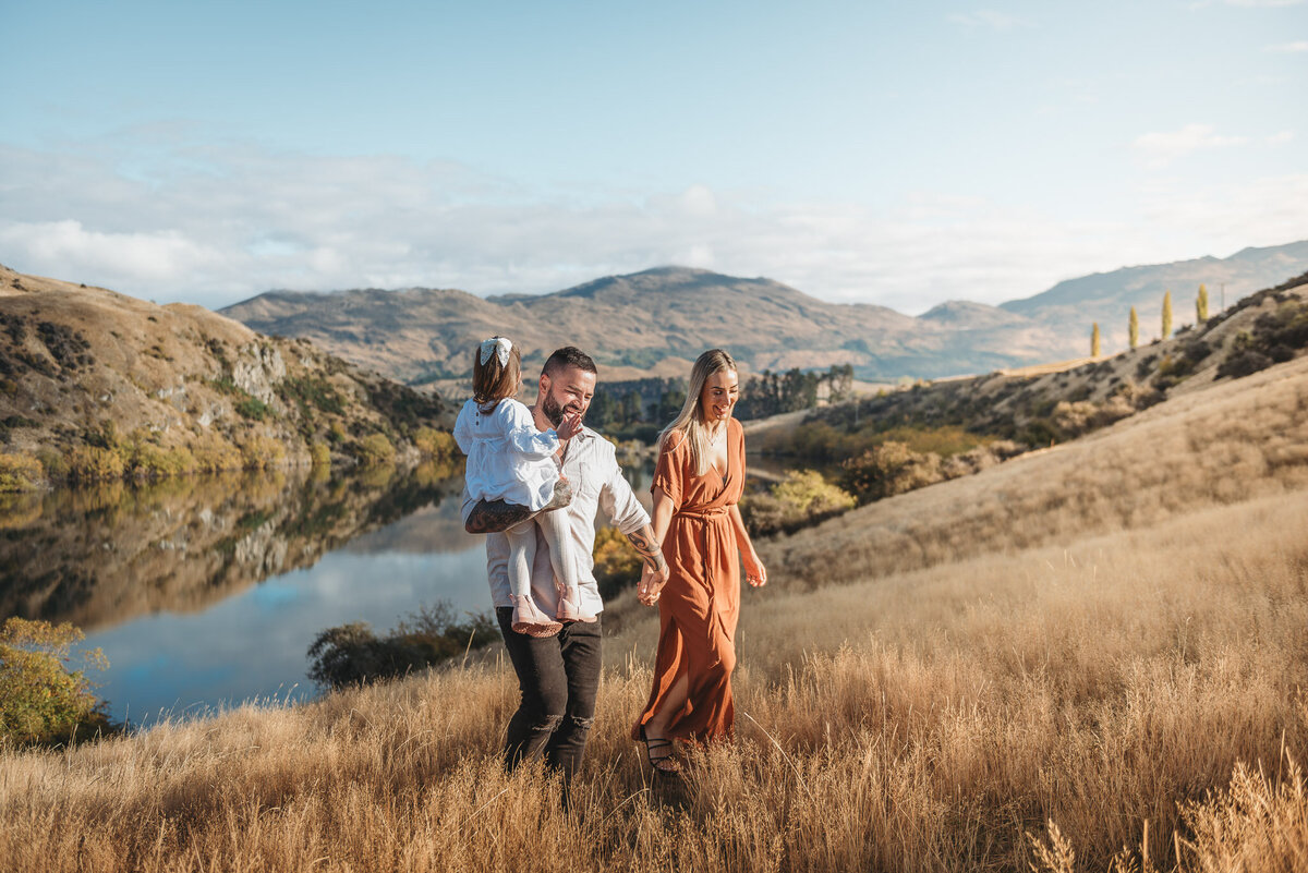 a family walking up a hill during a Queenstown family photography session by Lake Johnson