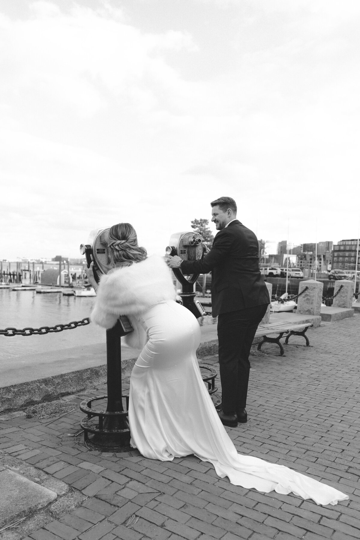 A bride and a groom looking out of binoculars in Boston, Massachusetts