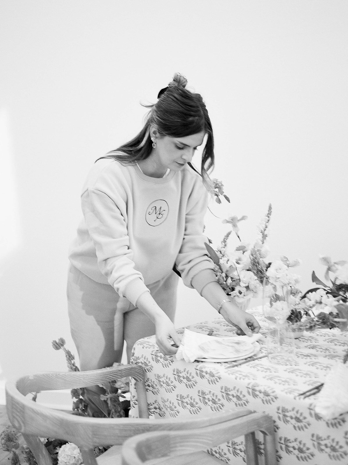 Margot adjusting the details on a tablescape designed by Margot & Co Creative