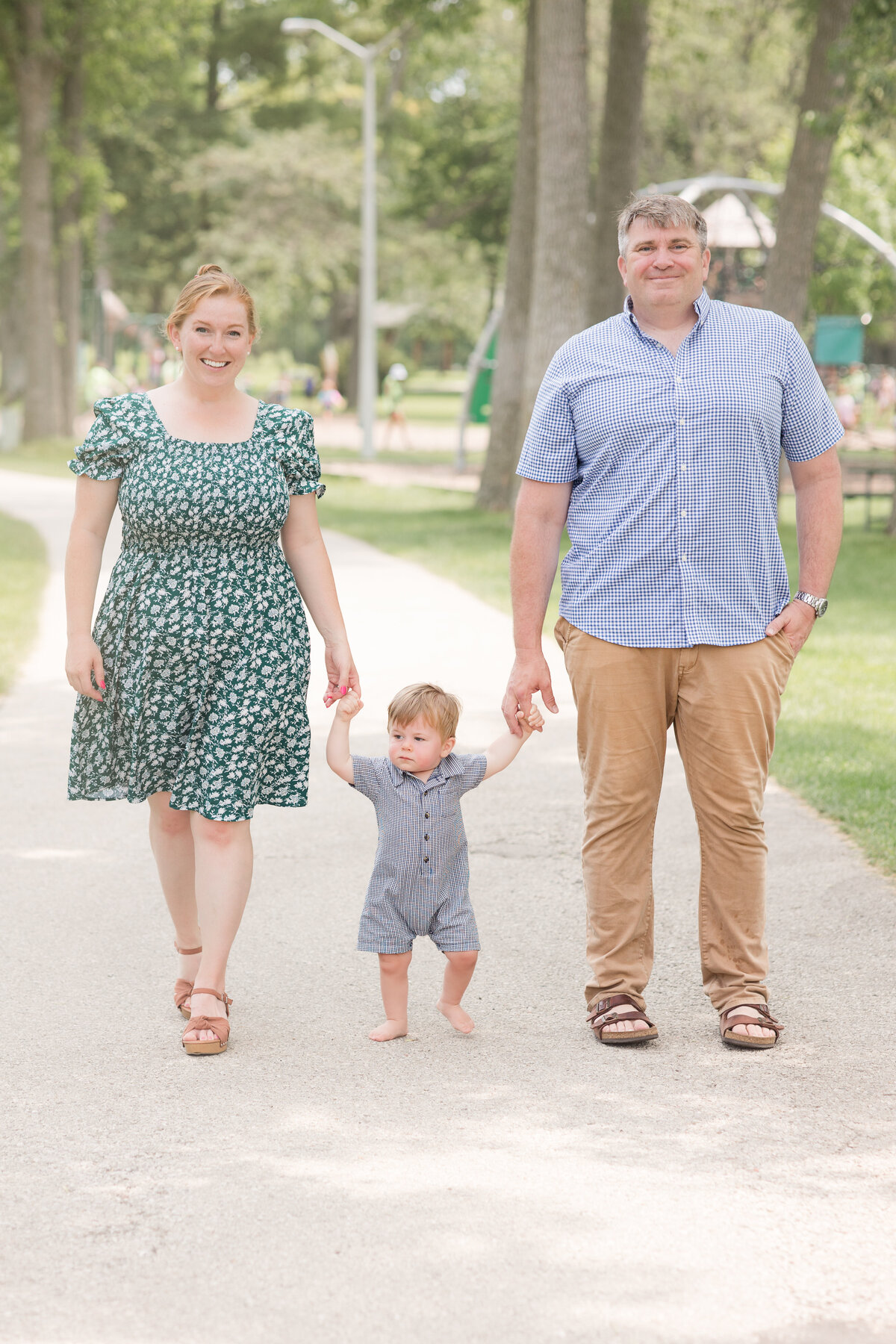 A family is walking along a path and smiling at the camera